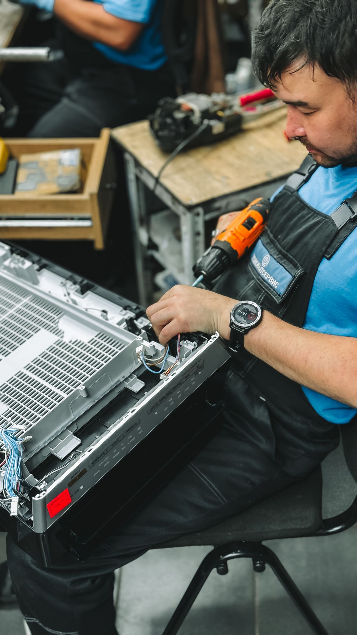 Technician inspecting a dishwasher spray arm for a cloudy dishes troubleshooting guide