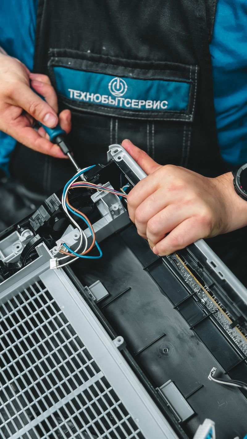 Technician repairing an appliance control panel with hand tools