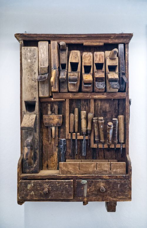Free A collection of vintage wooden carpentry tools neatly arranged on rustic shelving. Perfect for woodworking enthusiasts. Stock Photo