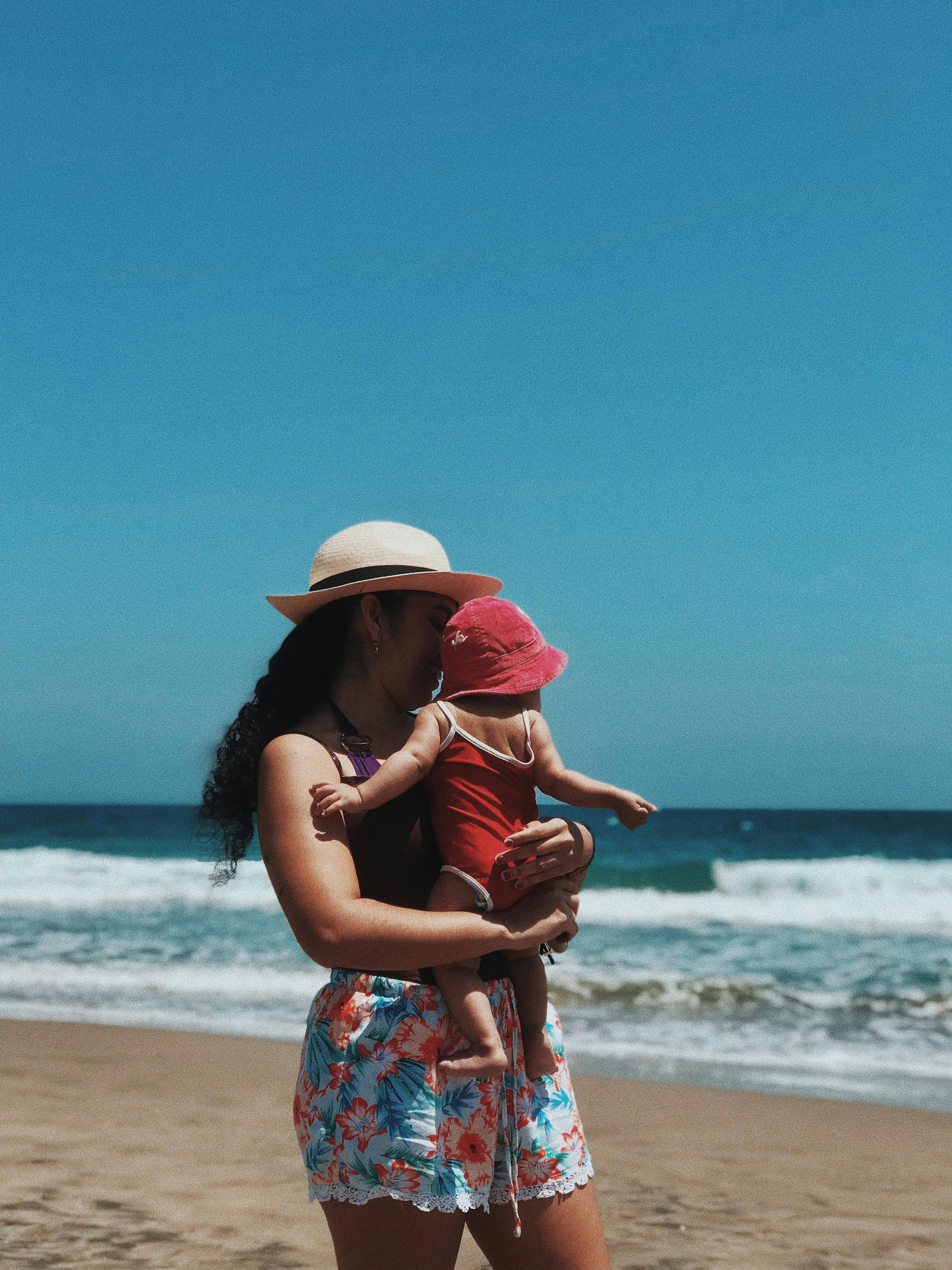 mother carrying her baby at the beach