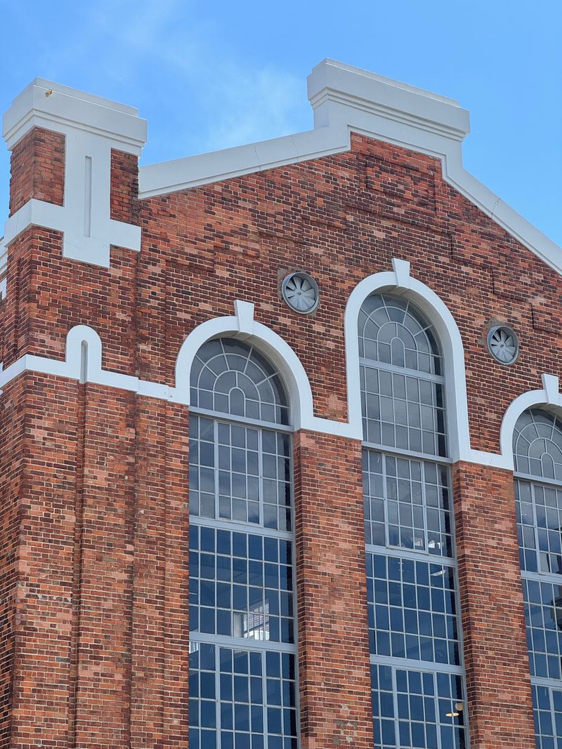 Historic brick building with large windows, showing aged mortar joints
