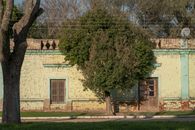 A rustic rural house with exposed brick and trees in Punta del Agua, Córdoba, Argentina.