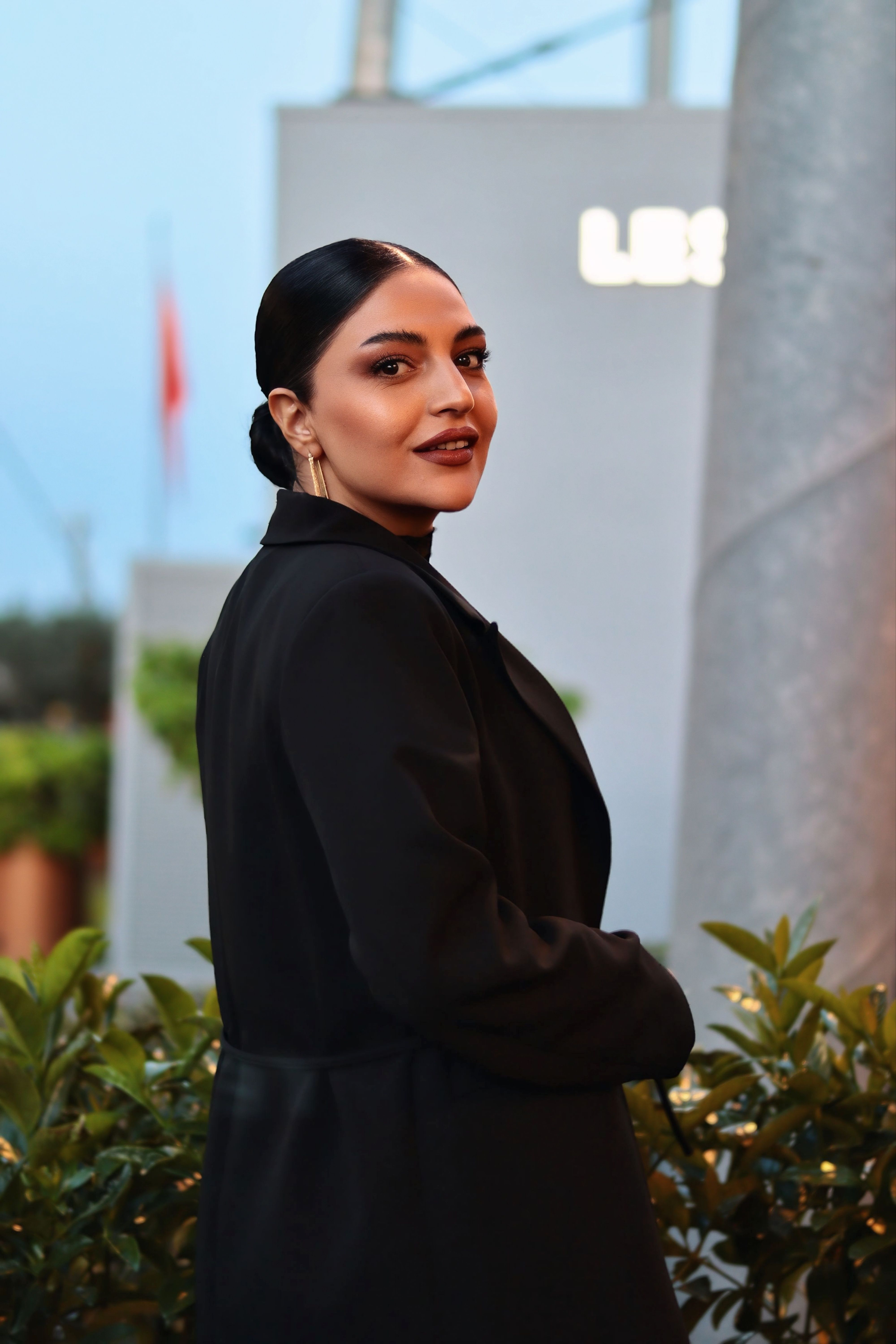 Portrait of a woman in black coat outdoors, evening light ambiance.