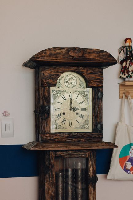 A rustic antique wall clock showcasing intricate craftsmanship in a cozy indoor setting.