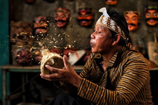 Javanese craftsman skillfully carving a wooden mask in Wonosobo, Indonesia.