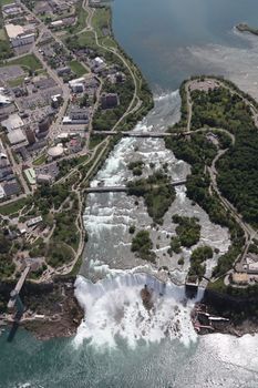 Stunning aerial view of Niagara Falls on a sunny day, showcasing its natural beauty and surrounding landscape.