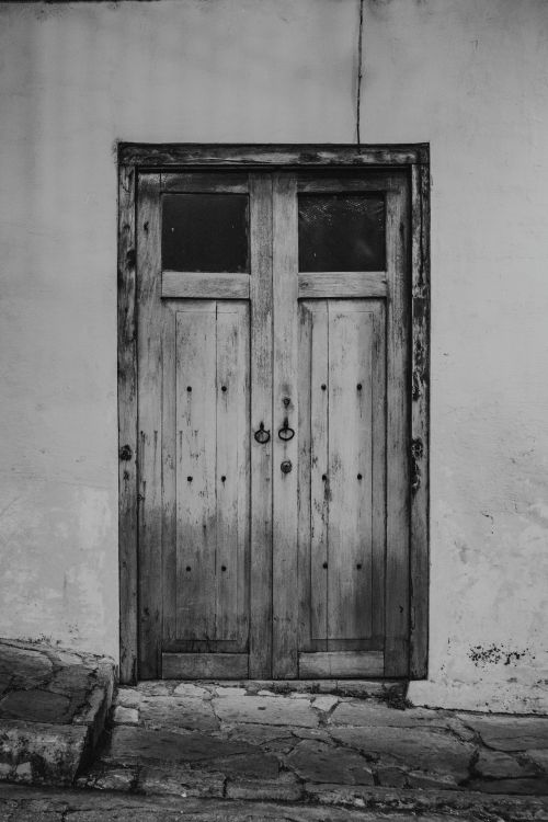 Free Black and white photo of a rustic wooden door in Comitán de Domínguez, Chiapas, showcasing colonial architecture. Stock Photo