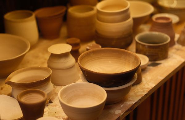 Freshly thrown bowls lined up on a workbench, photo by leo asher on Pexels