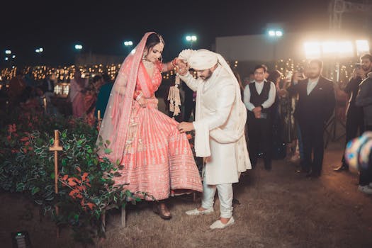 Beautiful Indian wedding ceremony held outdoors at night, featuring a bride and groom in traditional attire.