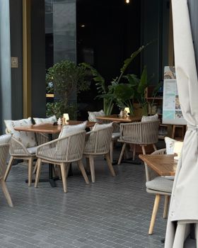 Inviting outdoor caf e in Dubai featuring elegant seating and lush plants, perfect for al fresco dining.