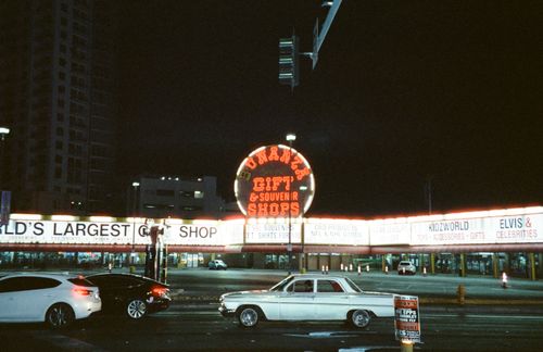 Free Vintage car in front of neon-lit souvenir shop at night in Las Vegas. Stock Photo