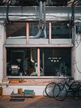 Charming coffee shop exterior with bikes and plants, capturing a cozy urban vibe.