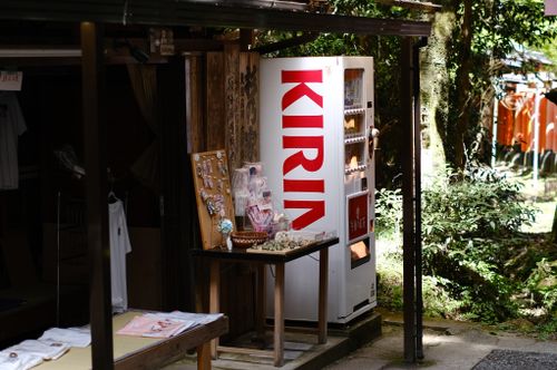 Free Outdoor vending machine at a Japanese market stall surrounded by greenery, offering snacks and beverages. Stock Photo