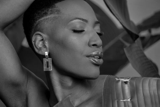 Elegant black and white portrait of a woman with geometric earrings and natural hairstyle.