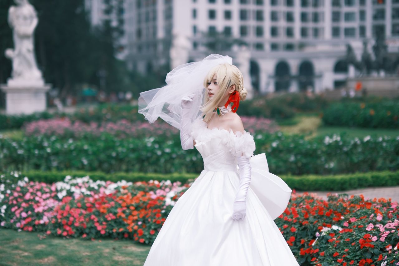 a bride in a stunning white gown poses in a vibrant garden with urban