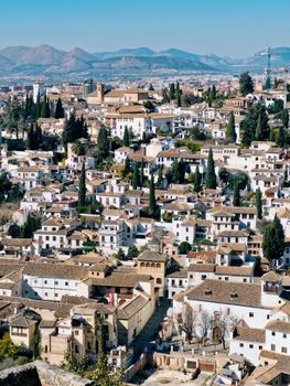 Aerial view of Granada's charming Albayzín neighborhood with distant mountains.
