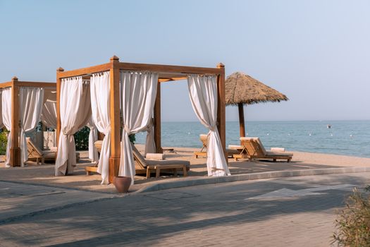 Elegant cabanas with ocean view on a sunny beach in Dubai, UAE. Perfect for relaxation and vacation.