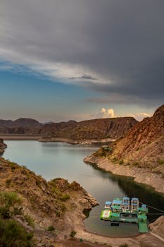 Dramatic sunset over a tranquil lake surrounded by rugged mountains in Mendoza, Argentina.