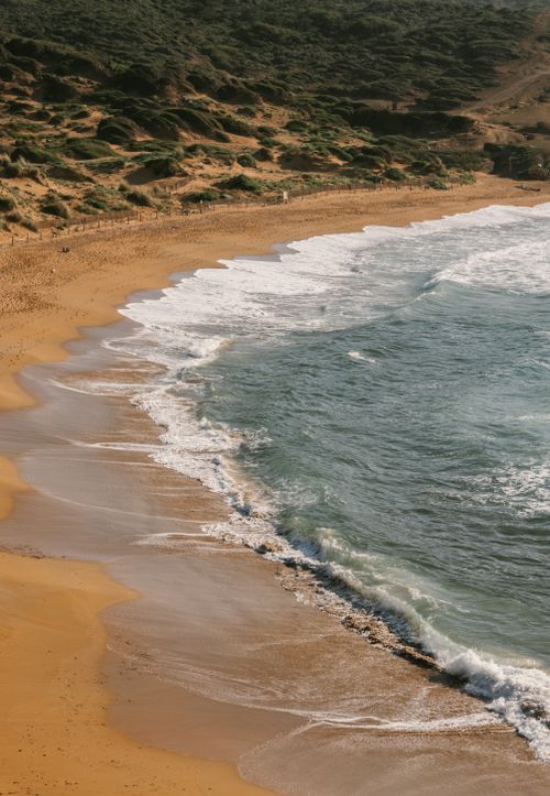 Free A tranquil sandy beach with gentle waves in Ciutadella de Menorca, Balearic Islands. Stock Photo