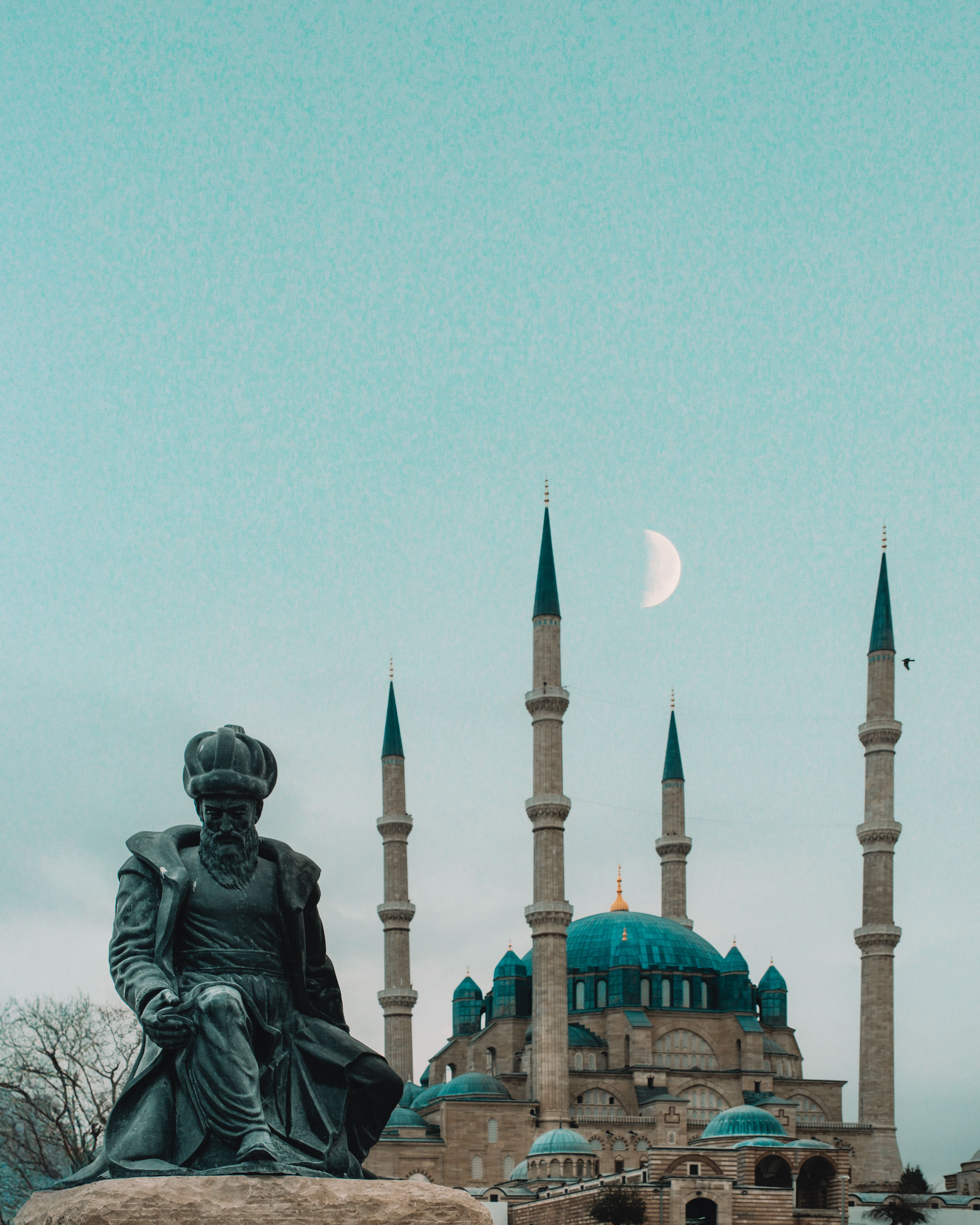 View of the Selimiye Mosque in Edirne, Türkiye, with iconic statue and crescent moon in the background.