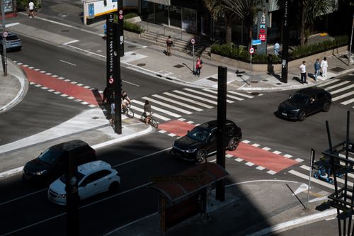 Free Dynamic aerial photo of an urban intersection in São Paulo with cars, cyclists, and pedestrians. Stock Photo