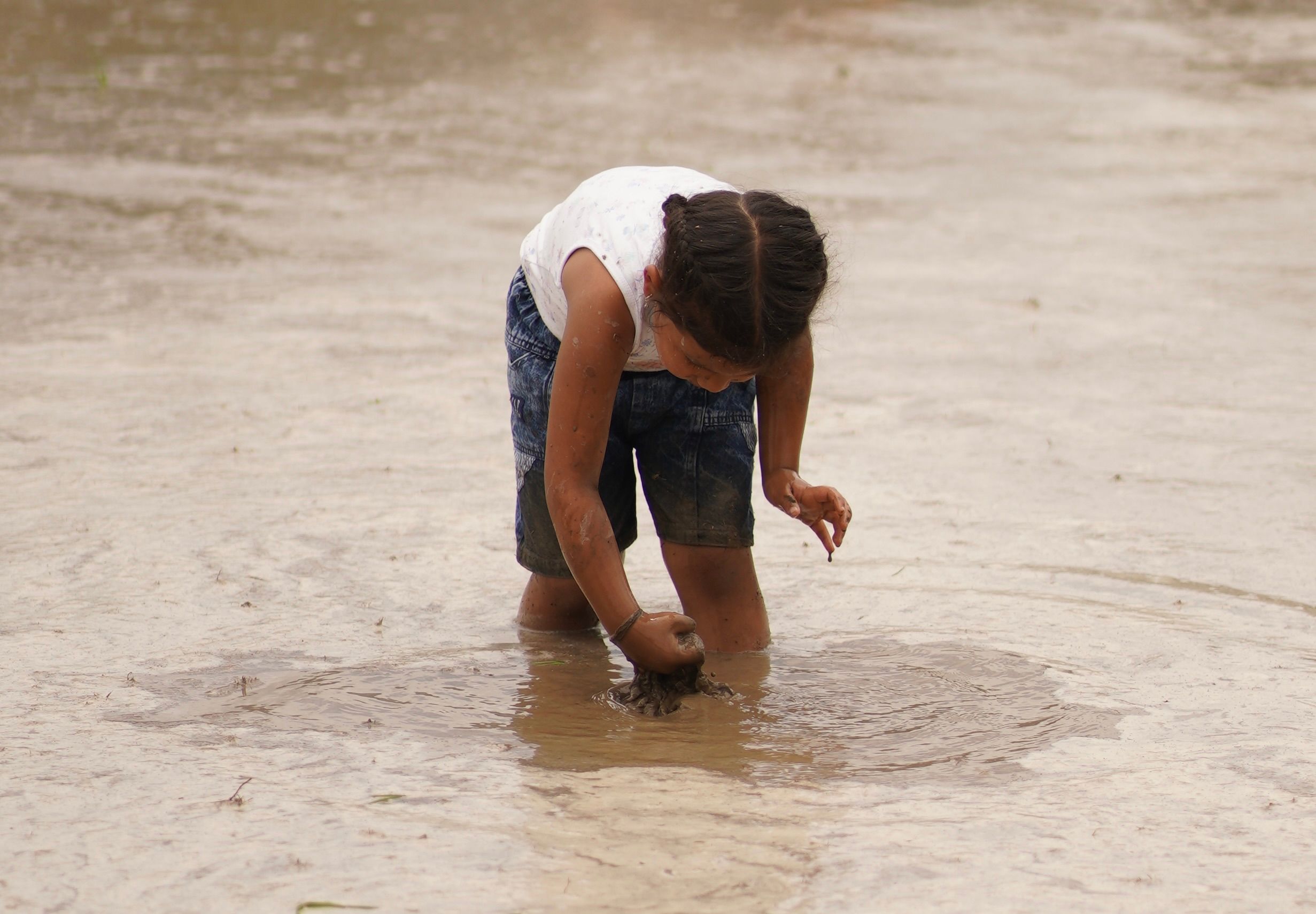 Child Playing in Mud Outdoors