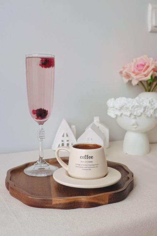 Free Stylish coffee cup and berry drink on a wooden tray with pink flowers in the background. Stock Photo