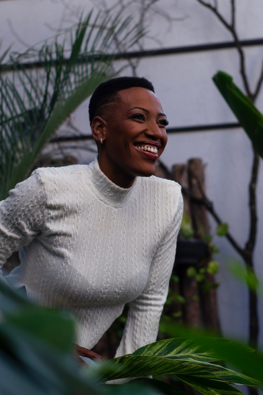 Amara smiling outdoors among garden foliage — photo by Cibele Bergamim on Pexels