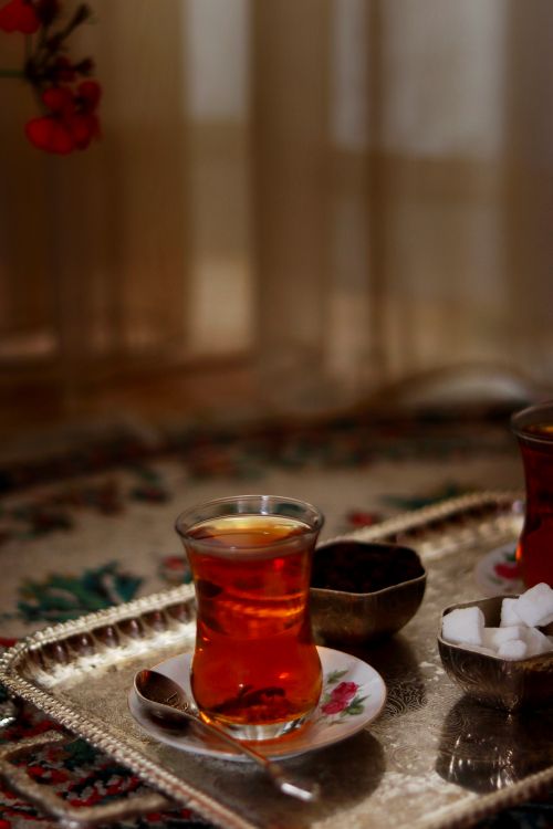 Free Sophisticated tea arrangement with glass cup, sugar cubes, and ornate tray. Stock Photo