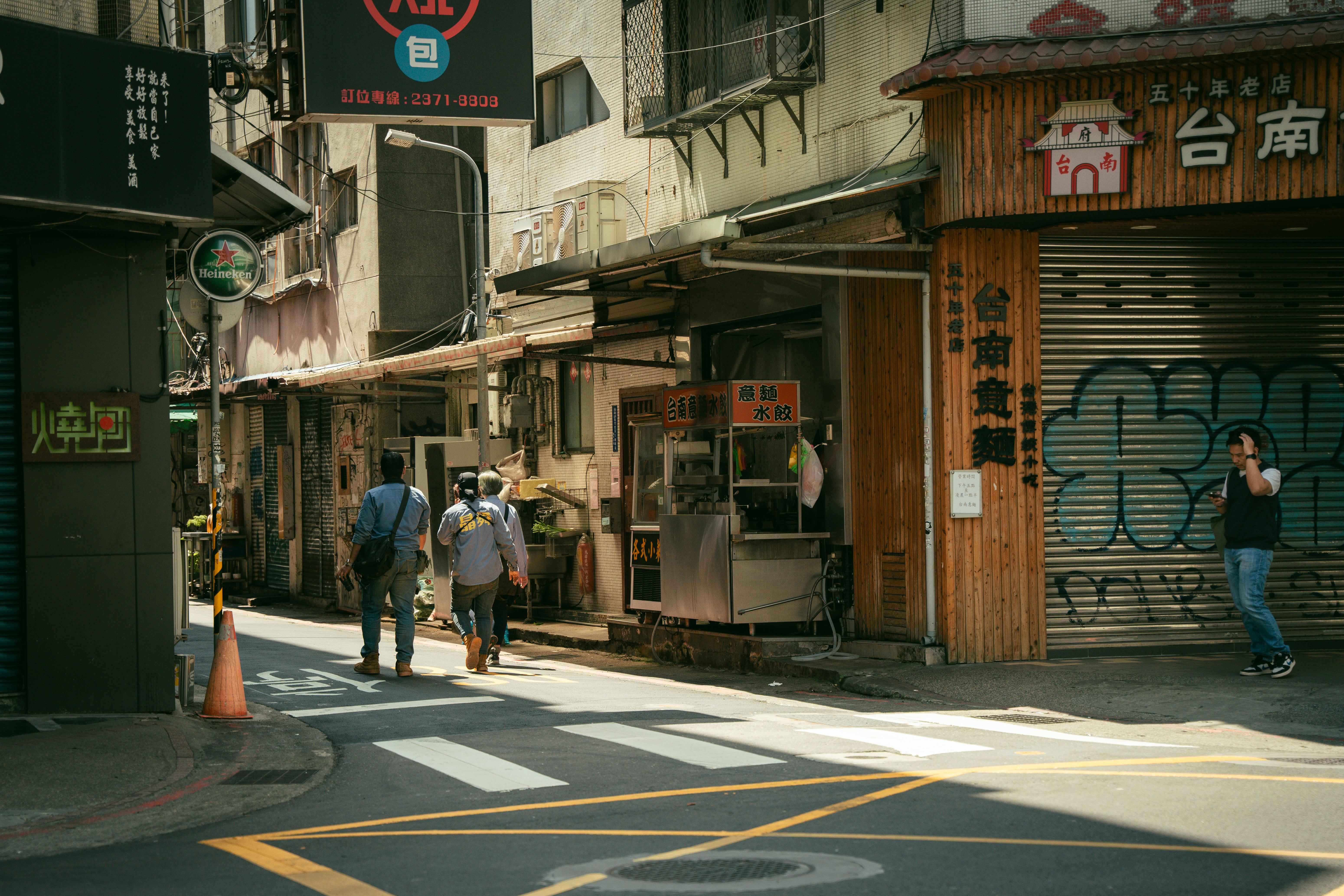 Urban street in Taipei, Taiwan with people walking and traditional shops