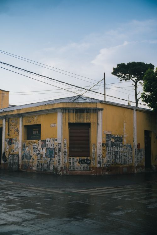 Free A vintage yellow building with graffiti on a rainy street in Ciudad de Guatemala. Stock Photo