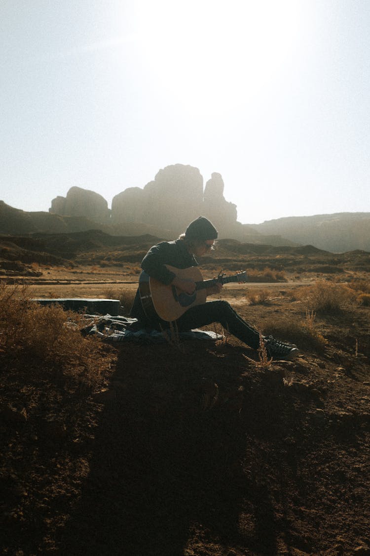 Man Playing The Guitar In Desert