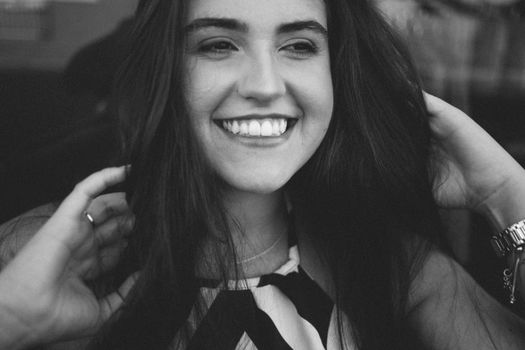 Captivating black and white portrait of a smiling woman in Jaraguá do Sul, Brazil.