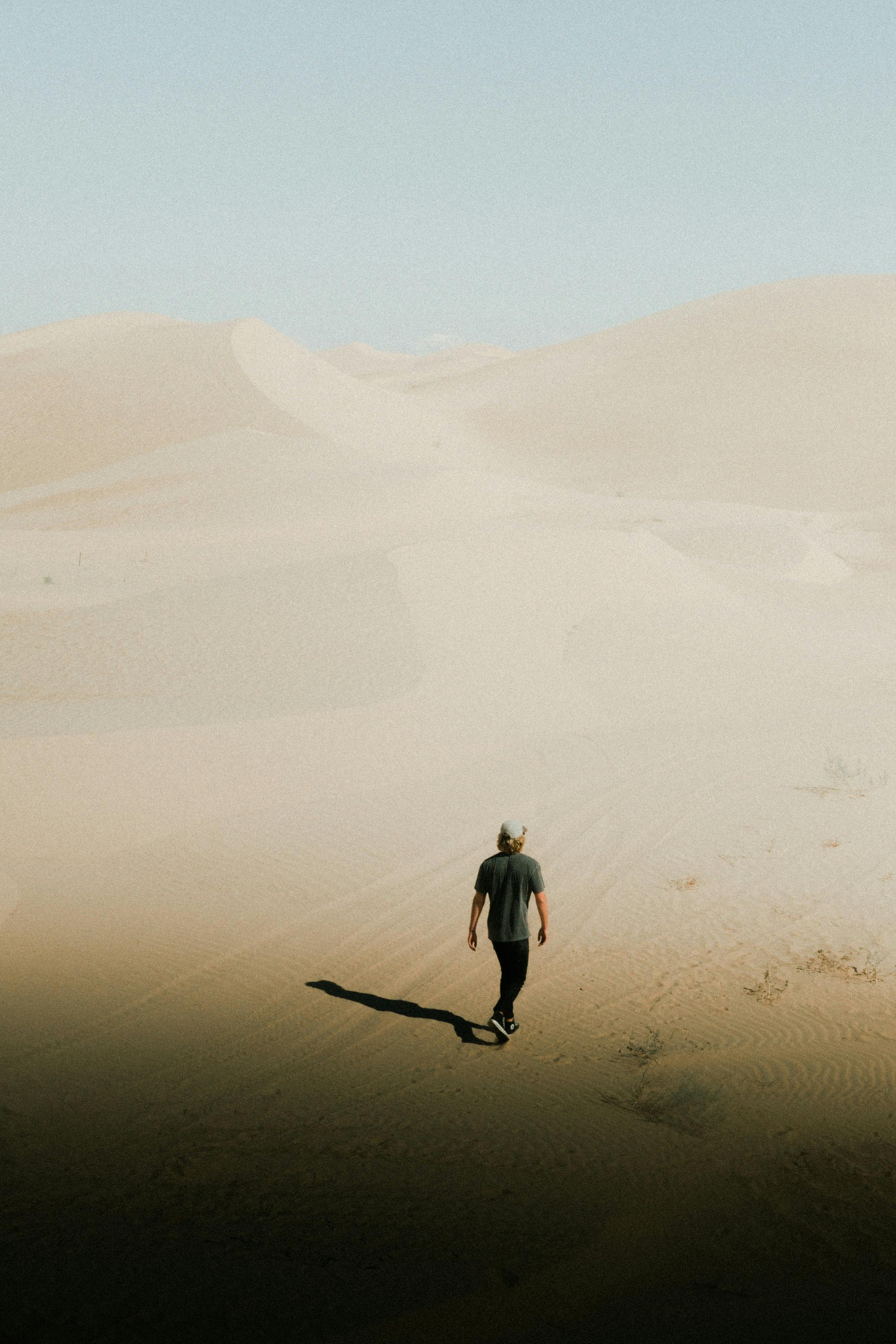 Photo Of Person Walking On Desert Free Stock Photo