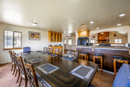 Explore this spacious and elegant dining room featuring contemporary design and a view of the kitchen area.