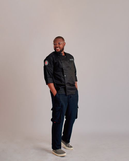 Free Chef in black uniform confidently posing, conveying professionalism and style. Stock Photo