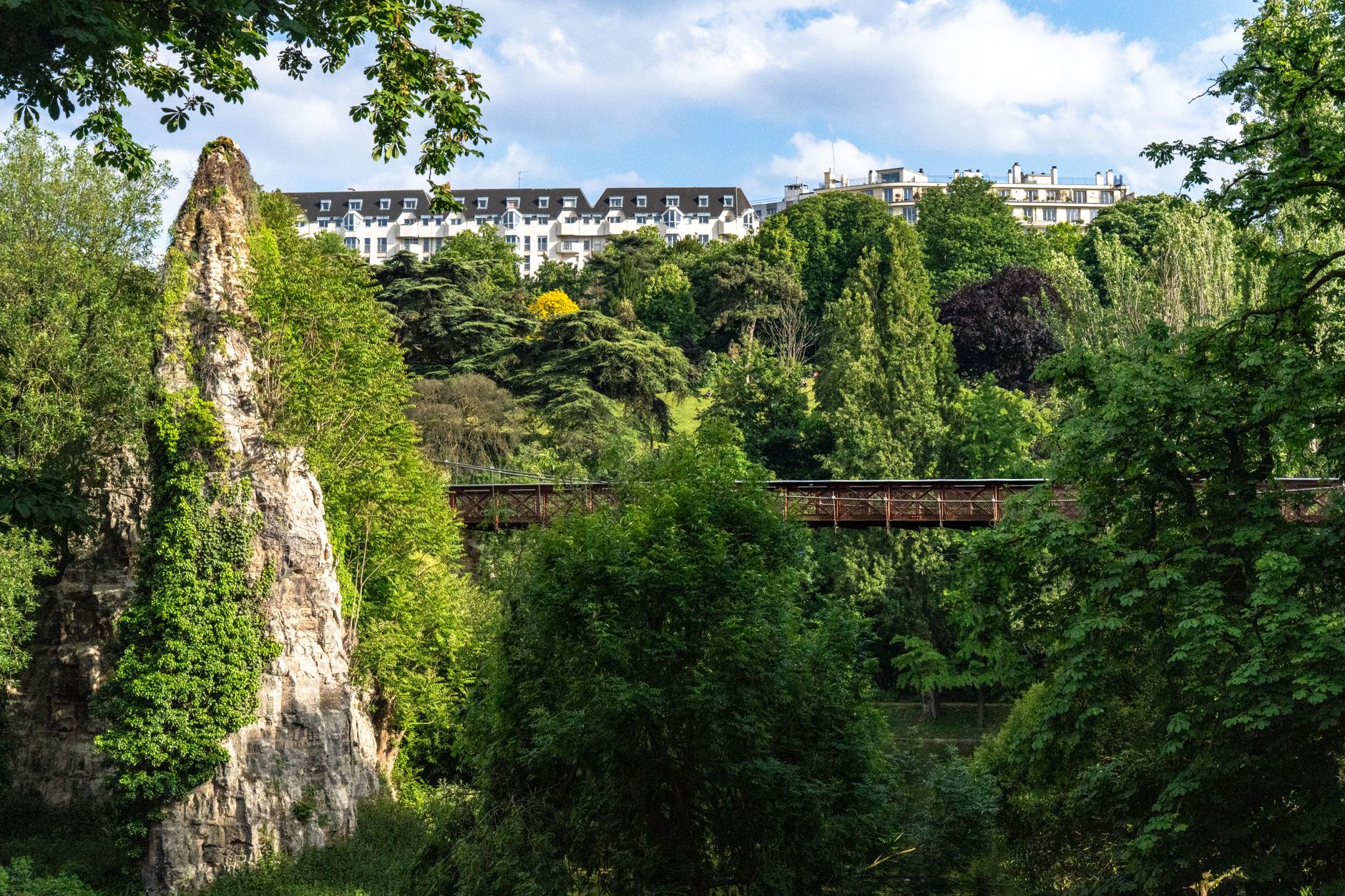 Scenic view of the suspension bridge and lake at Parc des Buttes-Chaumont