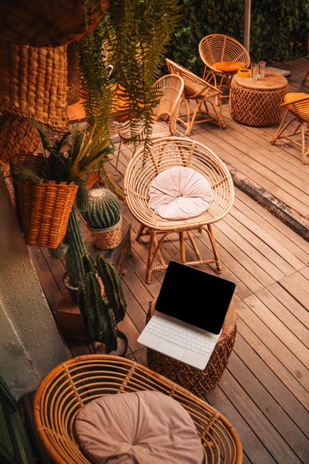 Inviting outdoor space with bamboo furniture and a laptop suggesting a remote work setup.