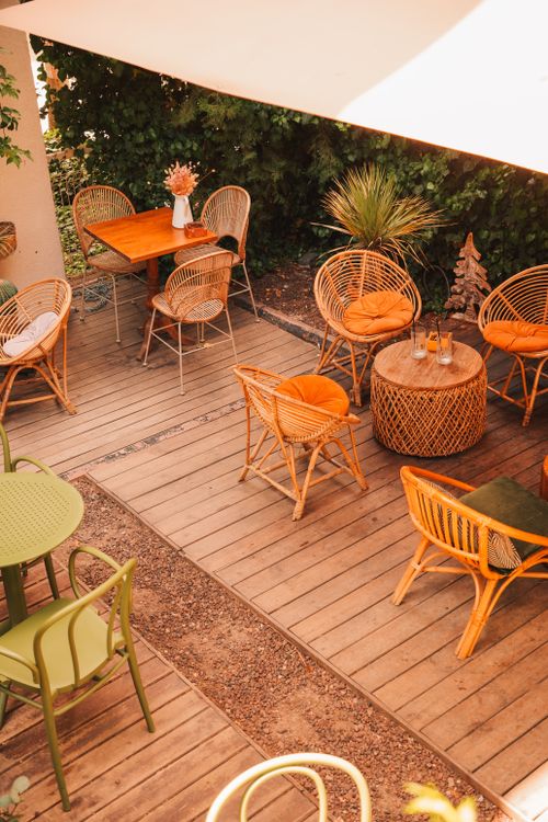 Free Charming outdoor patio with wicker chairs and wooden tables in warm tones. Stock Photo