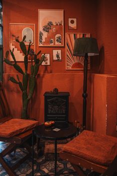 Warm orange interior with cactus, paintings, and furniture. Perfect for cozy home design inspiration.
