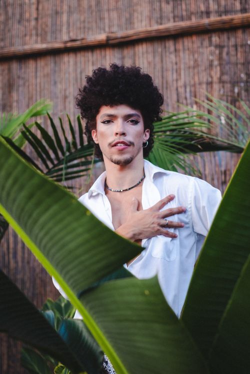 Free A striking portrait of a young man in São Paulo surrounded by lush greenery. Stock Photo