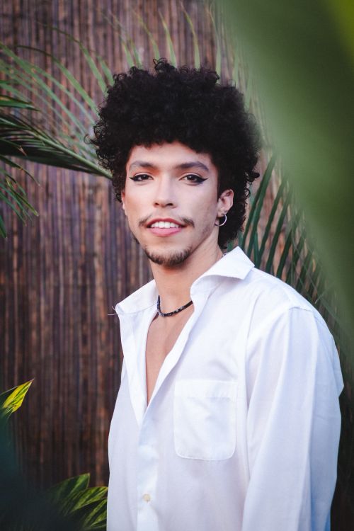 Free Portrait of a young man with afro hair, wearing white shirt, outdoors in São Paulo. Stock Photo