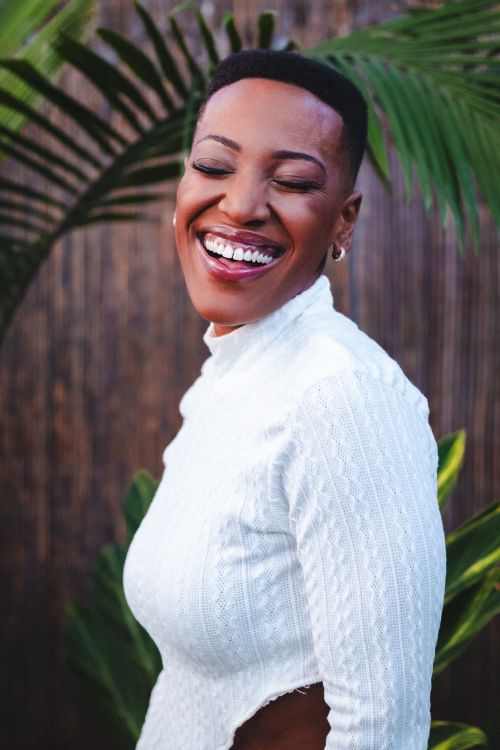 Free Vibrant portrait of a smiling woman in São Paulo, Brazil surrounded by lush greenery. Stock Photo