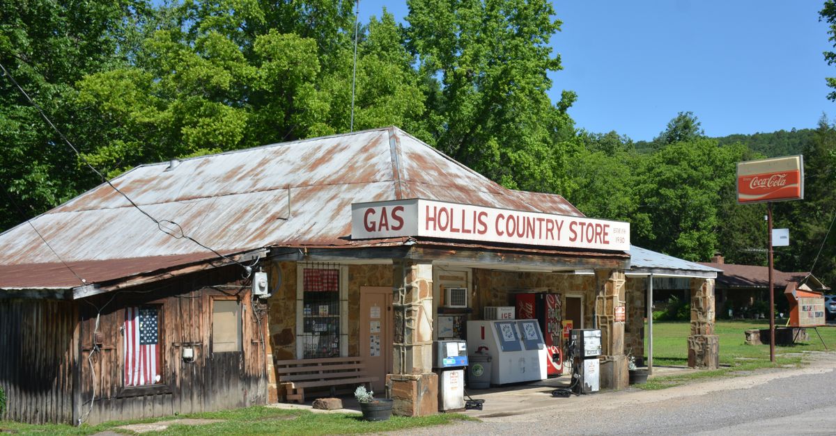 Charming vintage country store with gas pumps and Coca-Cola sign, tucked in rural greenery.