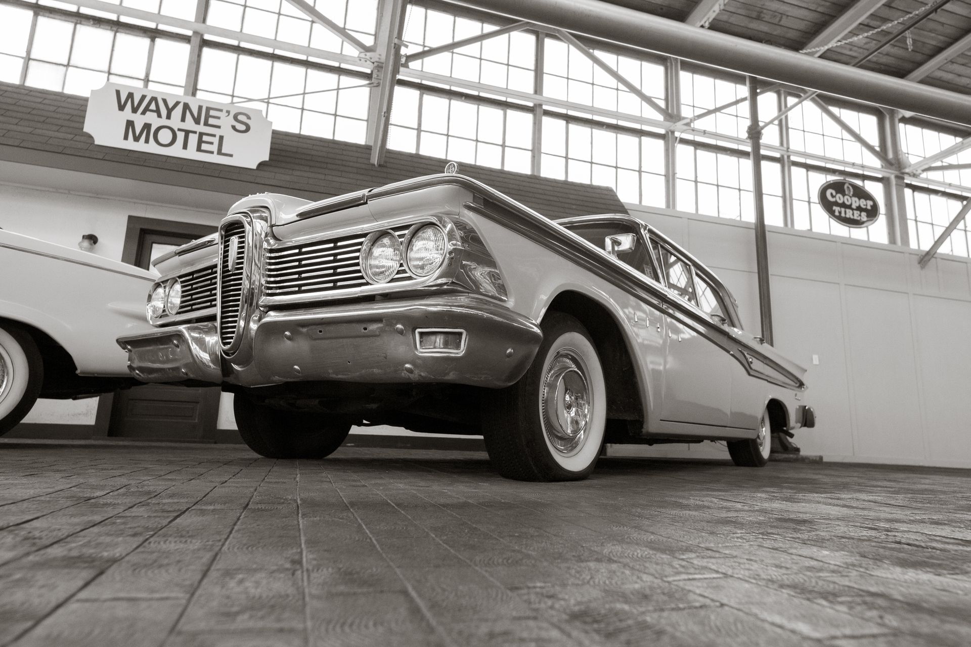 A vintage car parked indoors at Wayne's Motel with a retro ambiance.