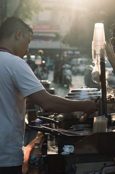 Street food vendor cooking in vibrant Hanoi, capturing the essence of Vietnamese street cuisine.
