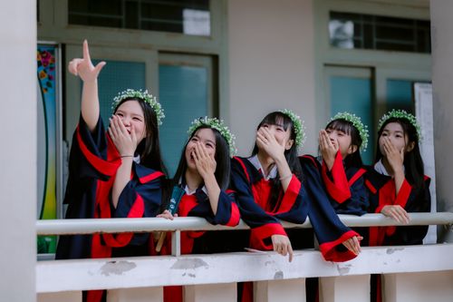 Free Group of five female graduates in gowns laughing and celebrating with joy. Stock Photo