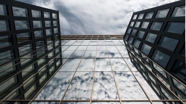 A stunning view of a glass facade reflecting clouds, located in Hamburg's architectural landscape.
