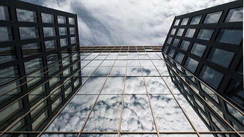Free A stunning view of a glass facade reflecting clouds, located in Hamburg's architectural landscape. Stock Photo