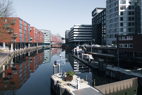 Free Modern office buildings reflected in a calm canal in Hamburg's business district. Stock Photo